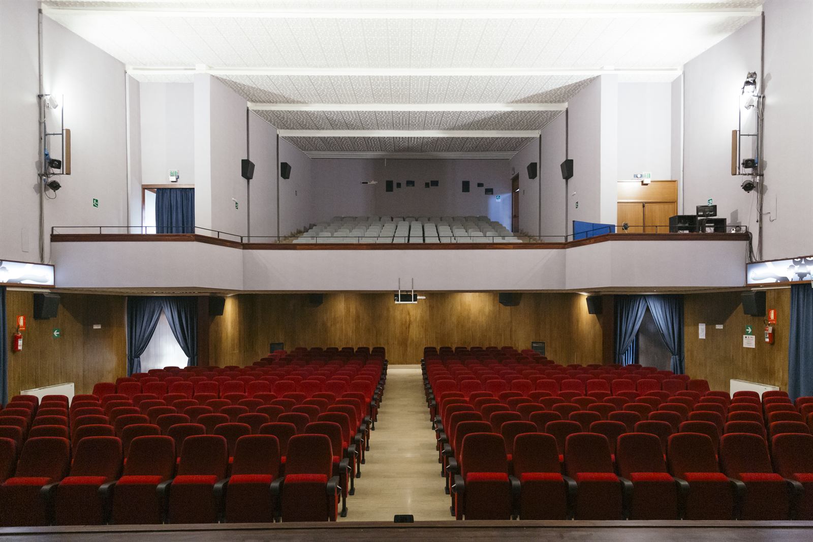 La sala vista dal palcoscenico: platea in velluto rosso, galleria e boiserie in legno